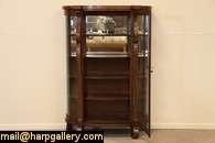 An American classic oak curved glass china or curio cabinet dates from 